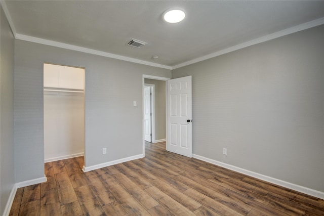 unfurnished bedroom with visible vents, a closet, baseboards, and dark wood-type flooring