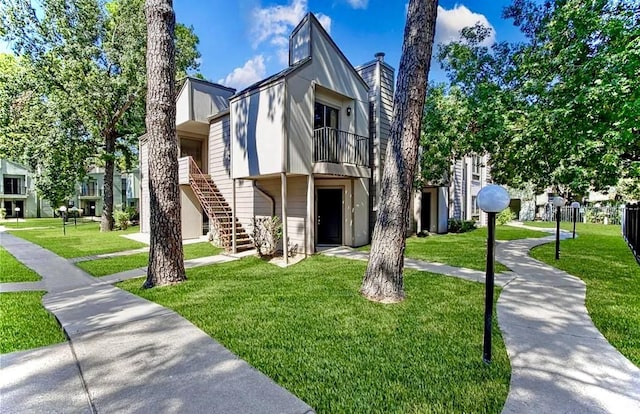 view of front of property with a chimney, stairway, and a front lawn