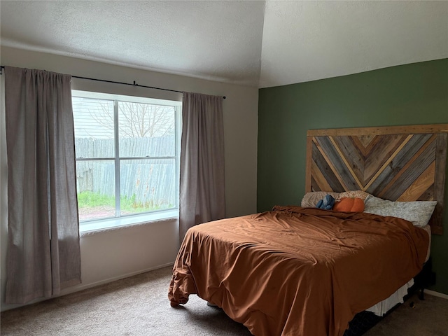 carpeted bedroom featuring a textured ceiling and baseboards