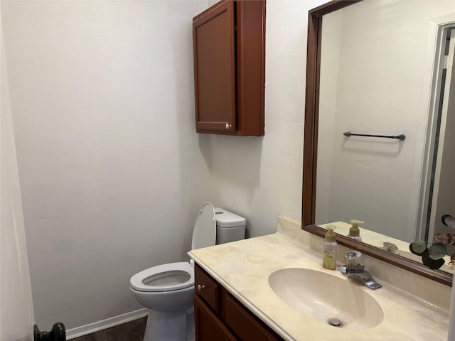 bathroom featuring vanity, toilet, and baseboards