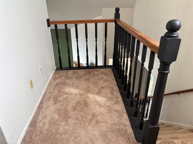 staircase featuring carpet floors and baseboards