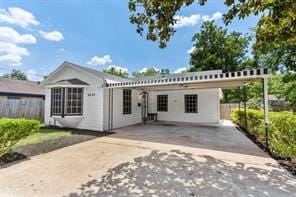 view of front facade featuring concrete driveway and fence