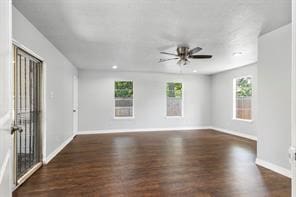 empty room featuring recessed lighting, wood finished floors, a wealth of natural light, and baseboards