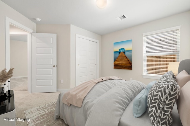 carpeted bedroom featuring a closet and visible vents