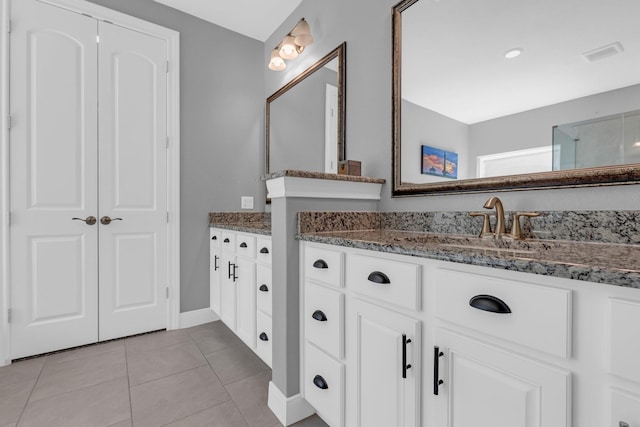 full bath with tile patterned flooring, visible vents, baseboards, and vanity