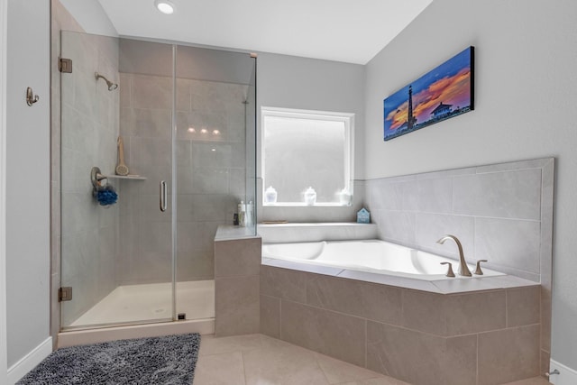 bathroom with a stall shower, a bath, and tile patterned floors