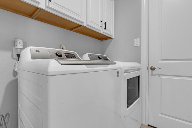 washroom featuring cabinet space and washer and dryer