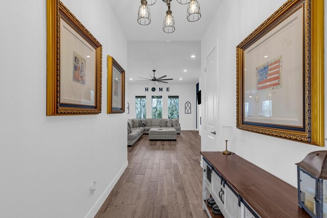 corridor with a chandelier, recessed lighting, dark wood finished floors, and baseboards