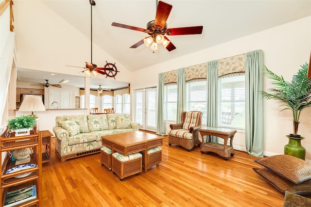 living room with light wood-type flooring, a wealth of natural light, and high vaulted ceiling