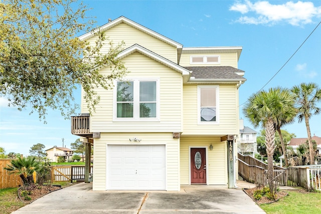 view of front of property with a garage, fence, concrete driveway, and roof with shingles