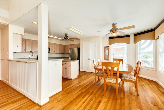 kitchen featuring ceiling fan, baseboards, light countertops, freestanding refrigerator, and light wood finished floors