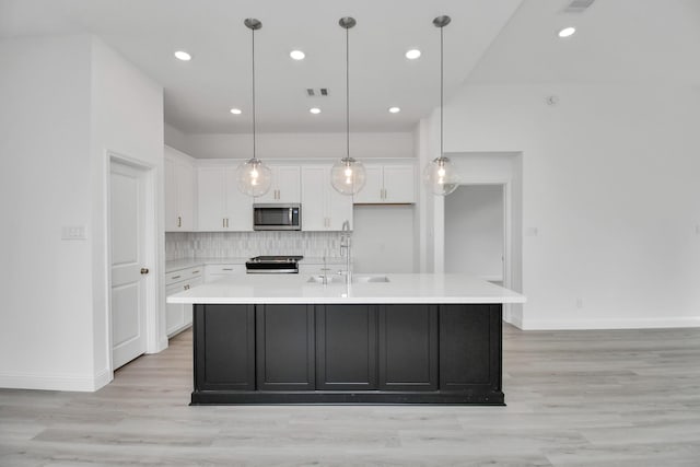 kitchen with appliances with stainless steel finishes, white cabinetry, a sink, and visible vents