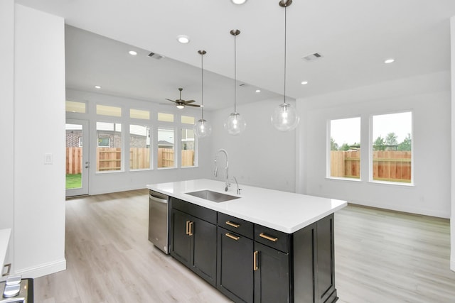 kitchen featuring stainless steel dishwasher, open floor plan, a sink, and light countertops