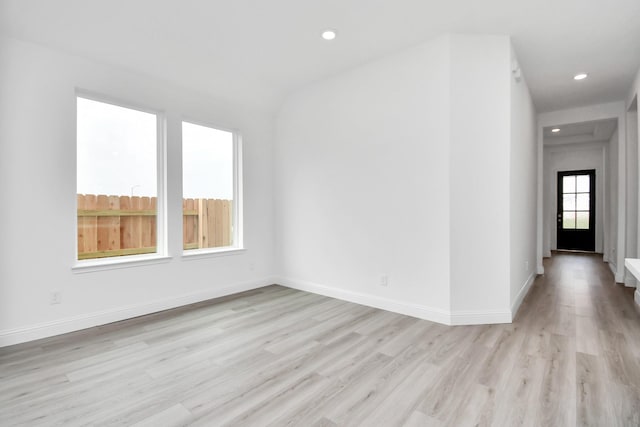 spare room featuring light wood finished floors, recessed lighting, and baseboards