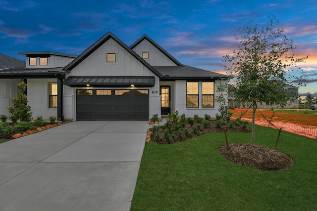 modern farmhouse with a standing seam roof, a garage, concrete driveway, a front lawn, and board and batten siding