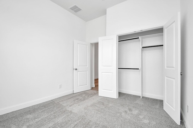 unfurnished bedroom featuring a closet, carpet, visible vents, and baseboards