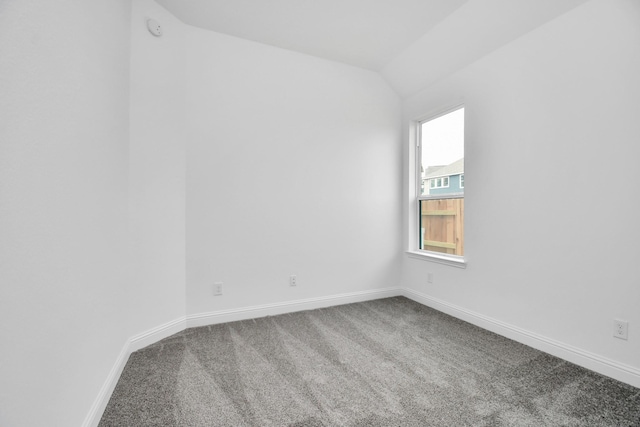 spare room with lofted ceiling, carpet flooring, and baseboards