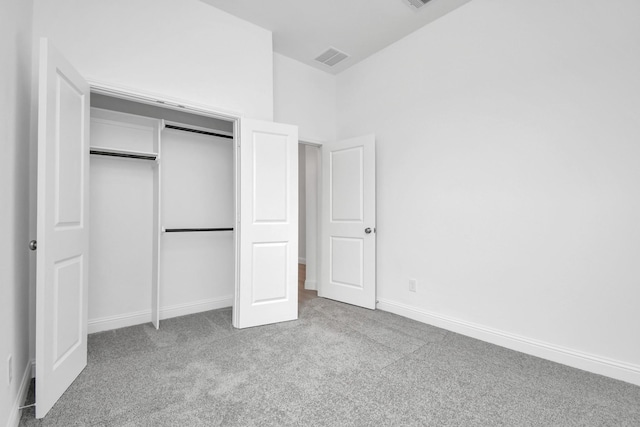 unfurnished bedroom with baseboards, a closet, visible vents, and carpet flooring