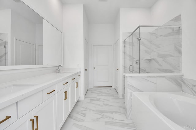 bathroom with marble finish floor, a garden tub, double vanity, a stall shower, and a sink