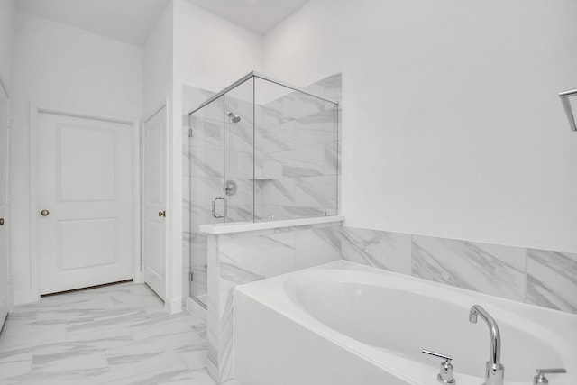 bathroom with a garden tub, a marble finish shower, and marble finish floor