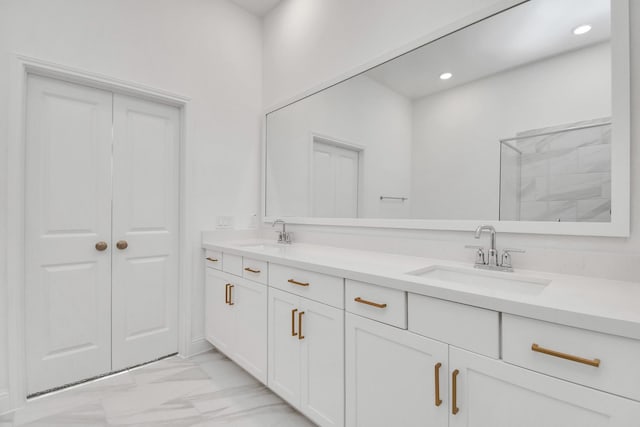 bathroom with recessed lighting, marble finish floor, a sink, and double vanity