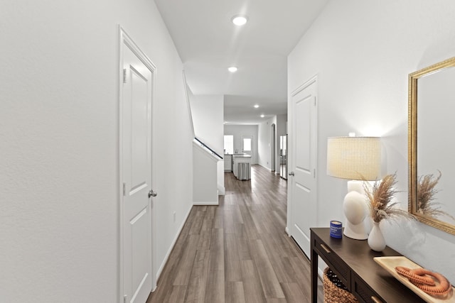 corridor featuring wood finished floors and recessed lighting