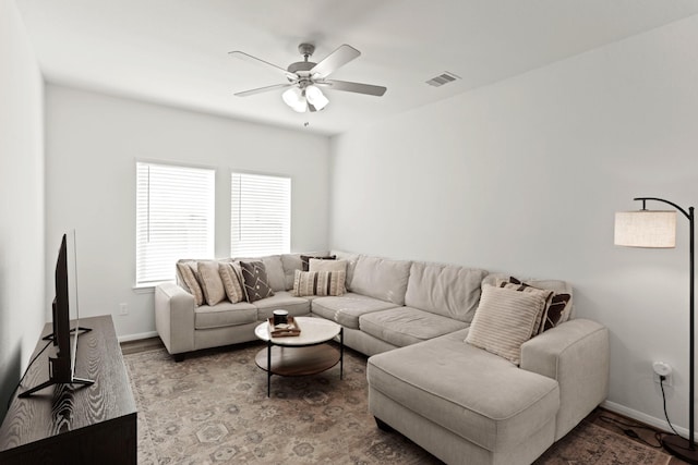 living area with ceiling fan, wood finished floors, visible vents, and baseboards