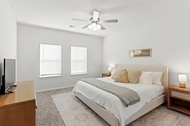 bedroom with light carpet, visible vents, baseboards, and ceiling fan