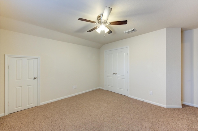 interior space with a ceiling fan, light colored carpet, visible vents, and baseboards