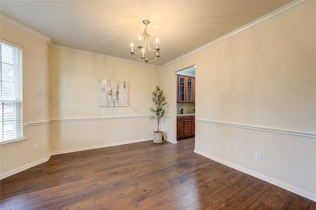 spare room featuring a chandelier, dark wood-type flooring, baseboards, and crown molding