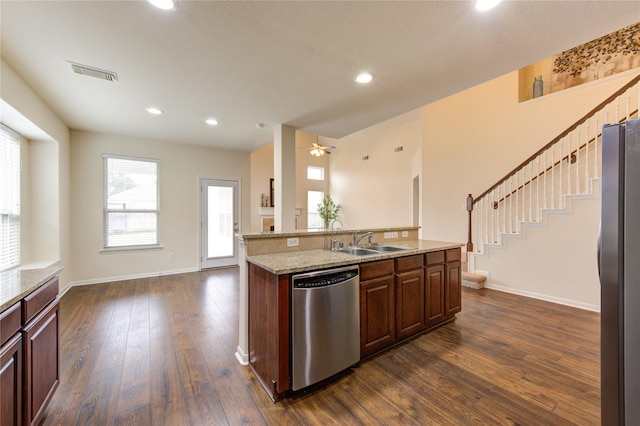 kitchen with a sink, visible vents, baseboards, appliances with stainless steel finishes, and dark wood finished floors