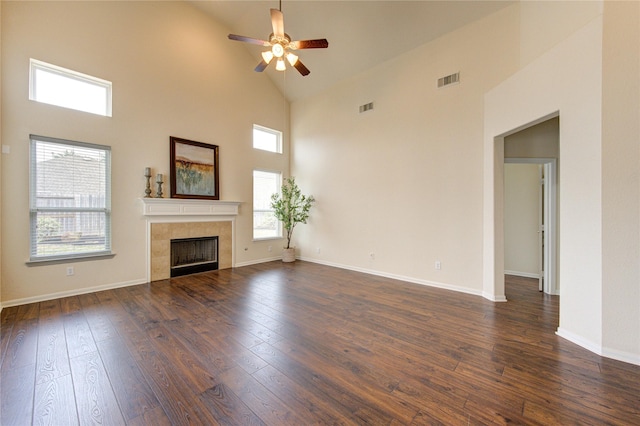 unfurnished living room with dark wood-type flooring, baseboards, visible vents, and a tiled fireplace