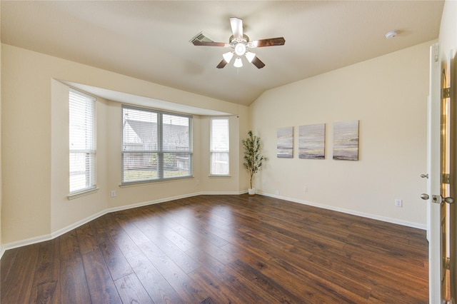 spare room with vaulted ceiling, ceiling fan, dark wood-type flooring, and baseboards