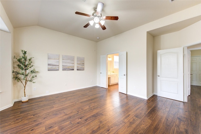 unfurnished bedroom featuring lofted ceiling, dark wood-type flooring, ensuite bath, and baseboards