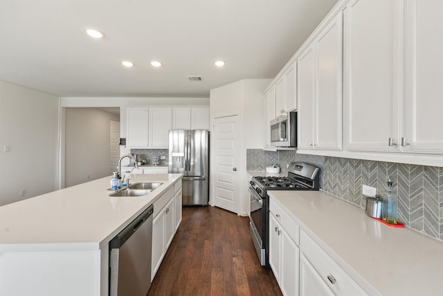 kitchen with stainless steel appliances, light countertops, a sink, and white cabinetry