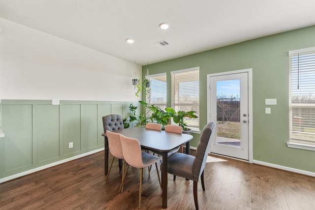 dining space featuring recessed lighting, wood finished floors, visible vents, and a decorative wall