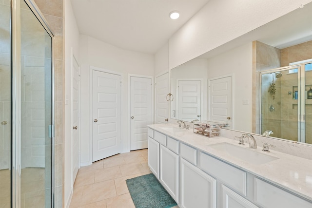 full bath featuring tile patterned flooring, a sink, a shower stall, and double vanity