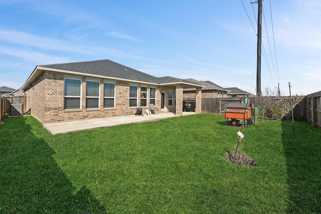 back of property featuring a patio, brick siding, a lawn, and a fenced backyard