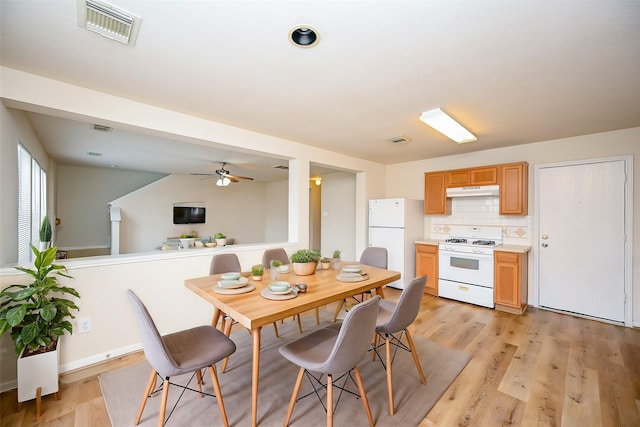 dining space featuring light wood-style flooring and visible vents