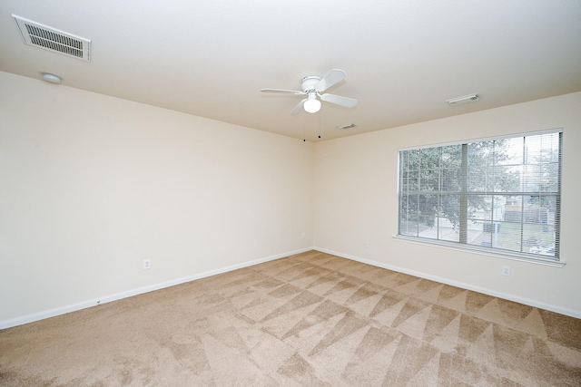 spare room featuring carpet, visible vents, and baseboards