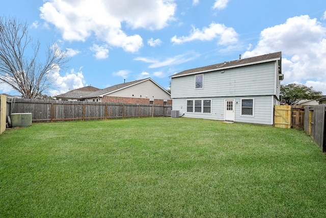 rear view of property featuring a yard, a fenced backyard, and cooling unit