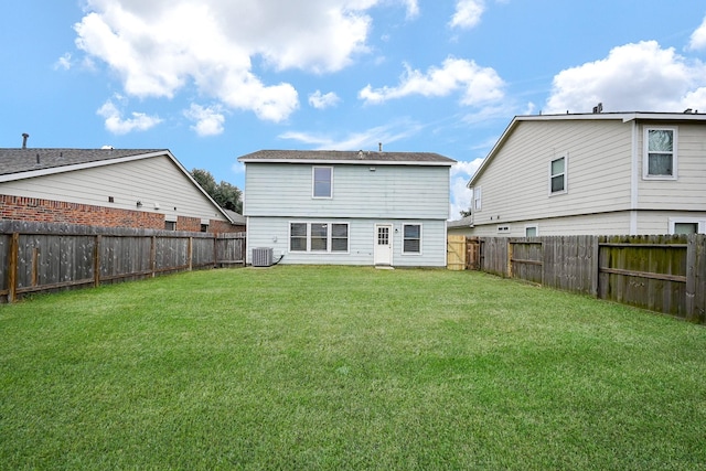 back of house featuring a yard, a fenced backyard, and central air condition unit