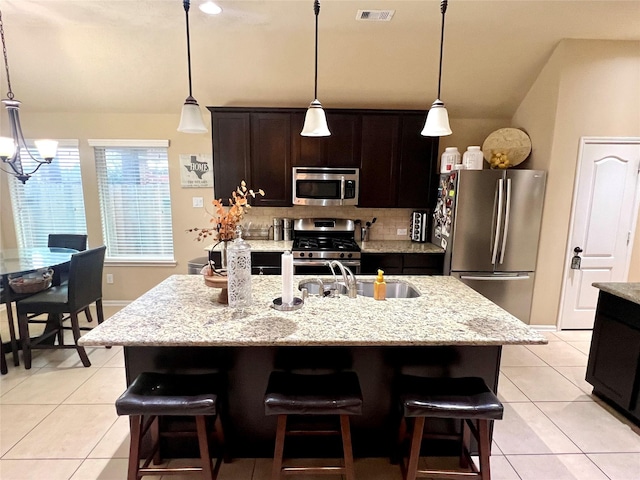 kitchen featuring appliances with stainless steel finishes, visible vents, backsplash, and light tile patterned floors