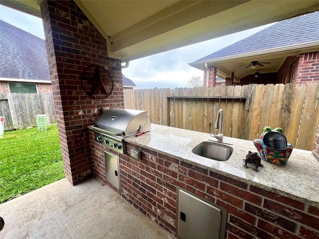 view of patio / terrace featuring an outdoor kitchen, fence, grilling area, and a sink