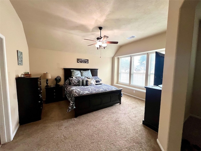 carpeted bedroom with vaulted ceiling, baseboards, visible vents, and a ceiling fan