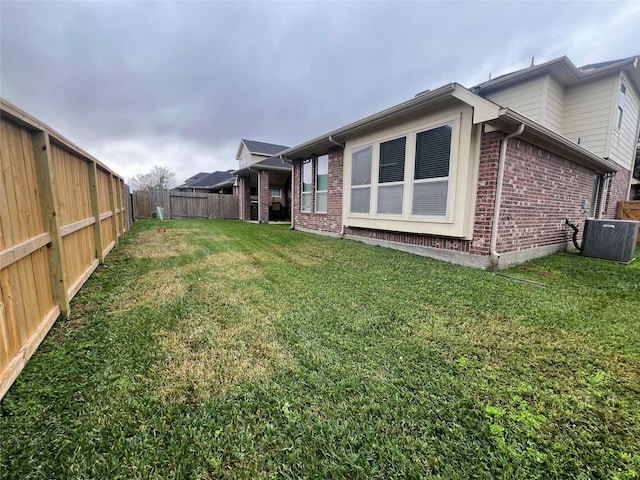 view of yard featuring a fenced backyard and central air condition unit