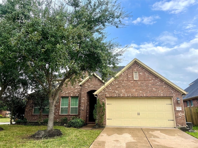 ranch-style home featuring driveway, brick siding, an attached garage, and a front yard