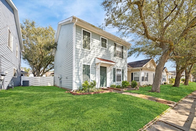 colonial home with fence and a front lawn