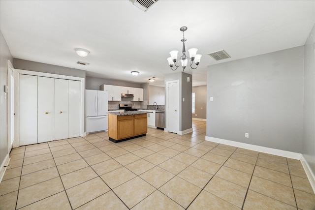 kitchen featuring visible vents, stainless steel appliances, decorative backsplash, and a center island