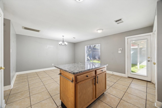 kitchen with light tile patterned flooring, visible vents, and a center island